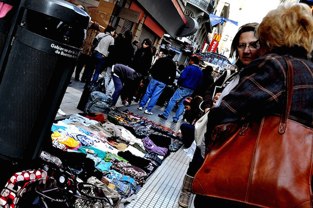 A pedlar sells t-shirts and other goods on Florida Street