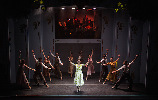 Dancers and singer on stage with the band above